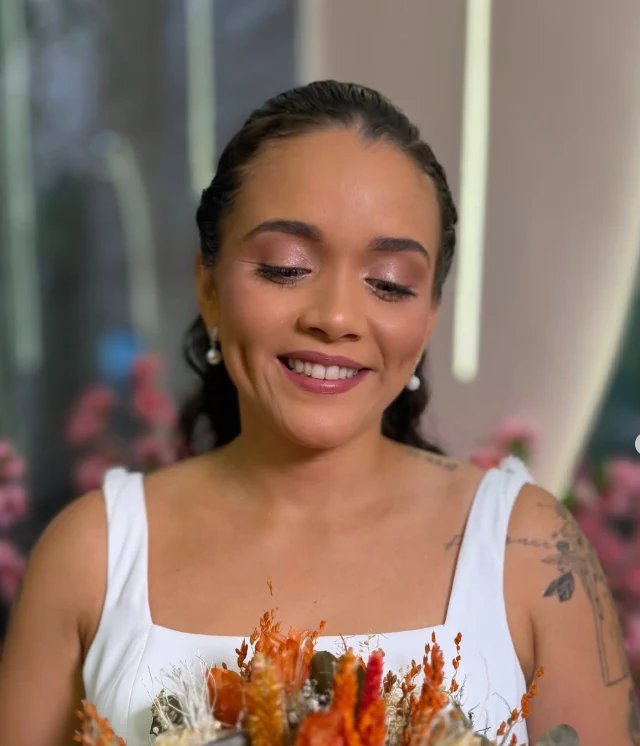 Noiva com buquê de flores secas em tons de laranja e maquiagem natural