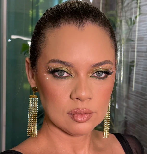 Olhar aberto com esfumado dourado, glitter e pedrarias no canto do olho