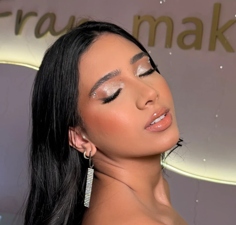 Make social com olhos fechados, sombra prateada e pedrarias no canto dos olhos